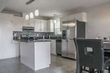 A kitchen with white cabinets and stainless steel appliances